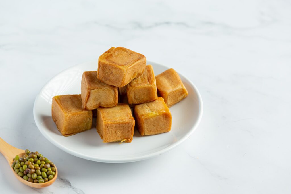 Beef bouillon cubes stacked on a wooden table with seasoning